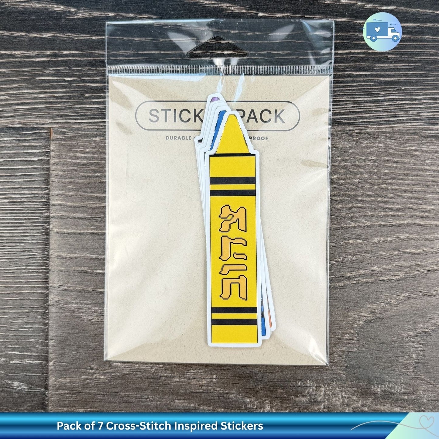 Pack of 7 Cross-Stitch Inspired Stickers with a yellow and black design on a clear plastic sheet against a wooden surface.