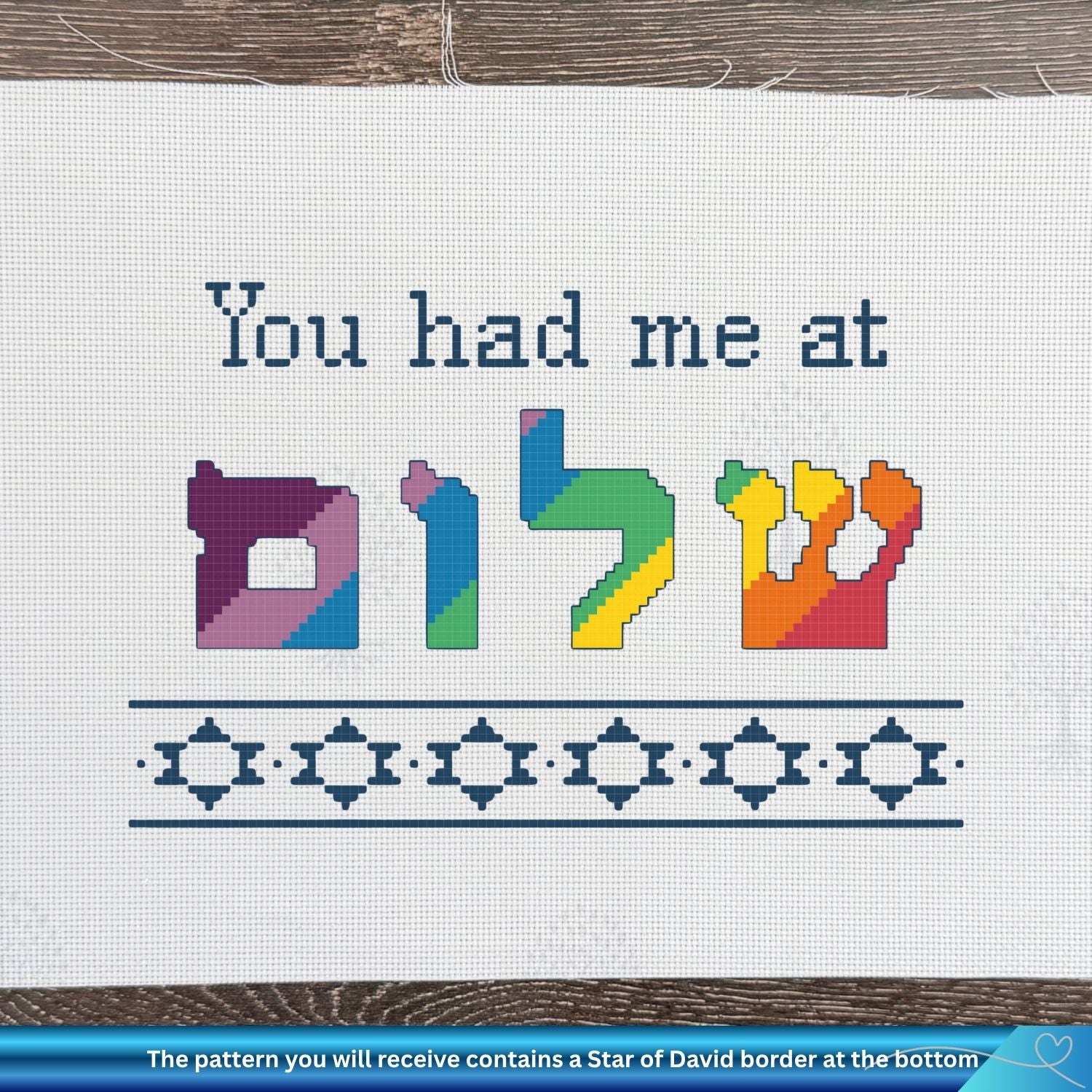 Cross-stitch pattern with colorful Hebrew letters and text on a white fabric background.