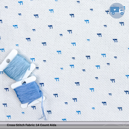 Cross-stitch fabric with blue Chai patterns and two spools of thread on a white background.