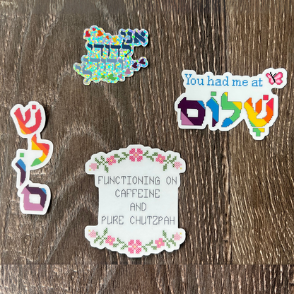 Five colorful stickers Hebrew with text and Jewish designs on a wooden surface