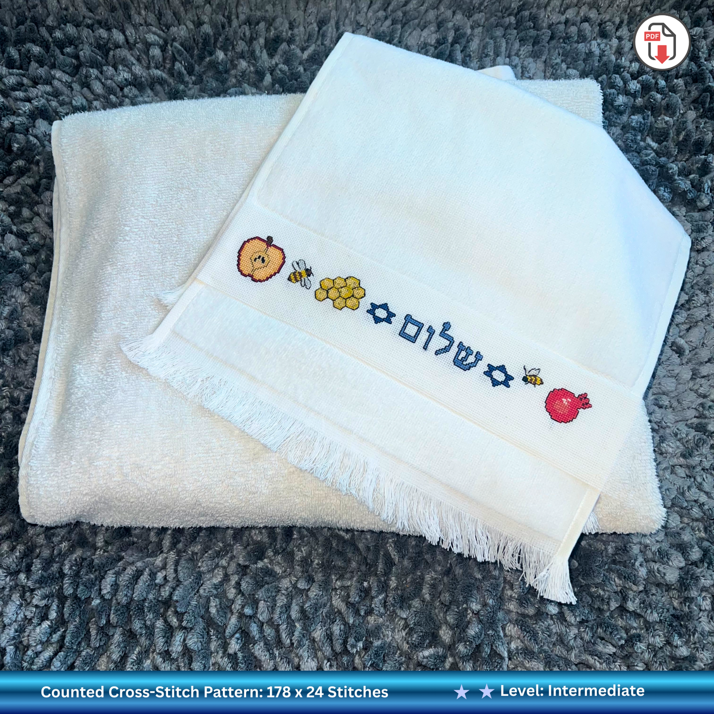 Folded white hand towel with embroidered Jewish Rosh Hashanah designs 