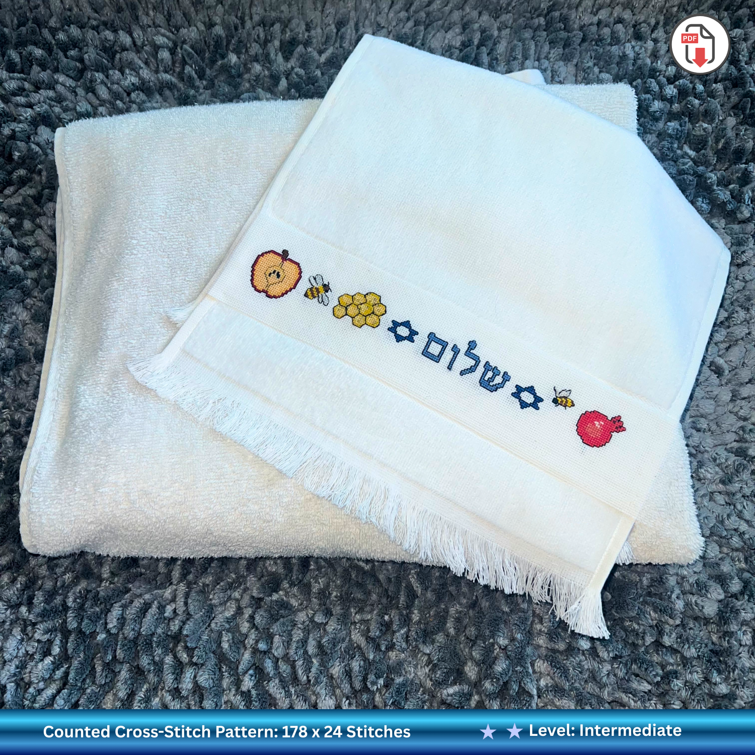 Folded white hand towel with embroidered Jewish Rosh Hashanah designs 