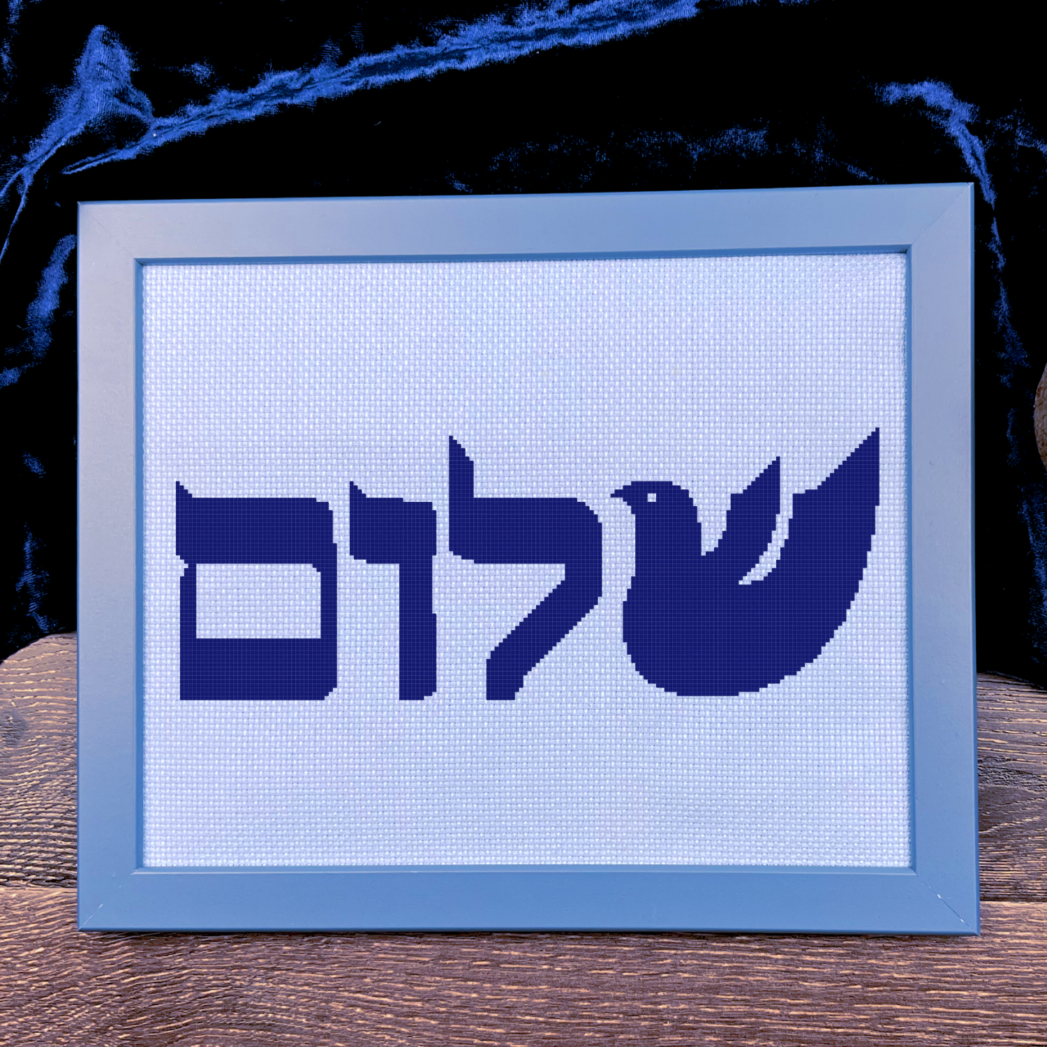 Framed artwork with Hebrew text and a dove symbol on a blue background