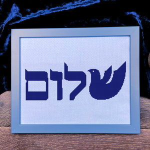 Framed artwork with Hebrew text and a dove symbol on a blue background