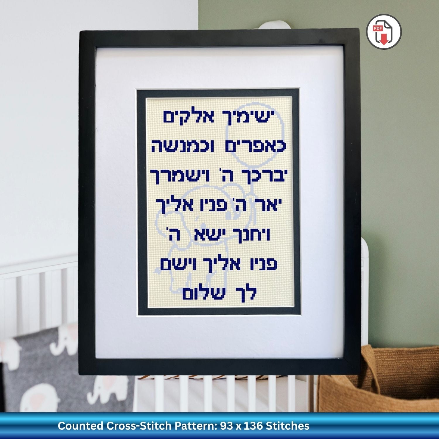 Framed cross-stitch pattern with Hebrew text in a baby room setting