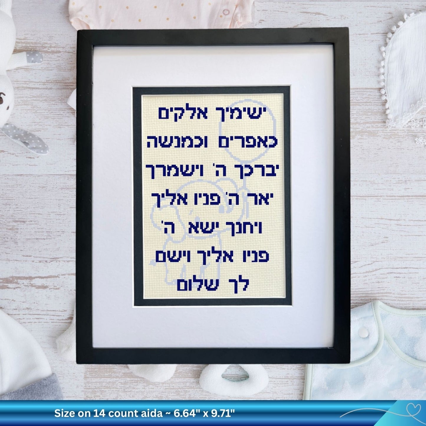 Framed cross-stitched artwork with baby elephant and Hebrew text on a white background