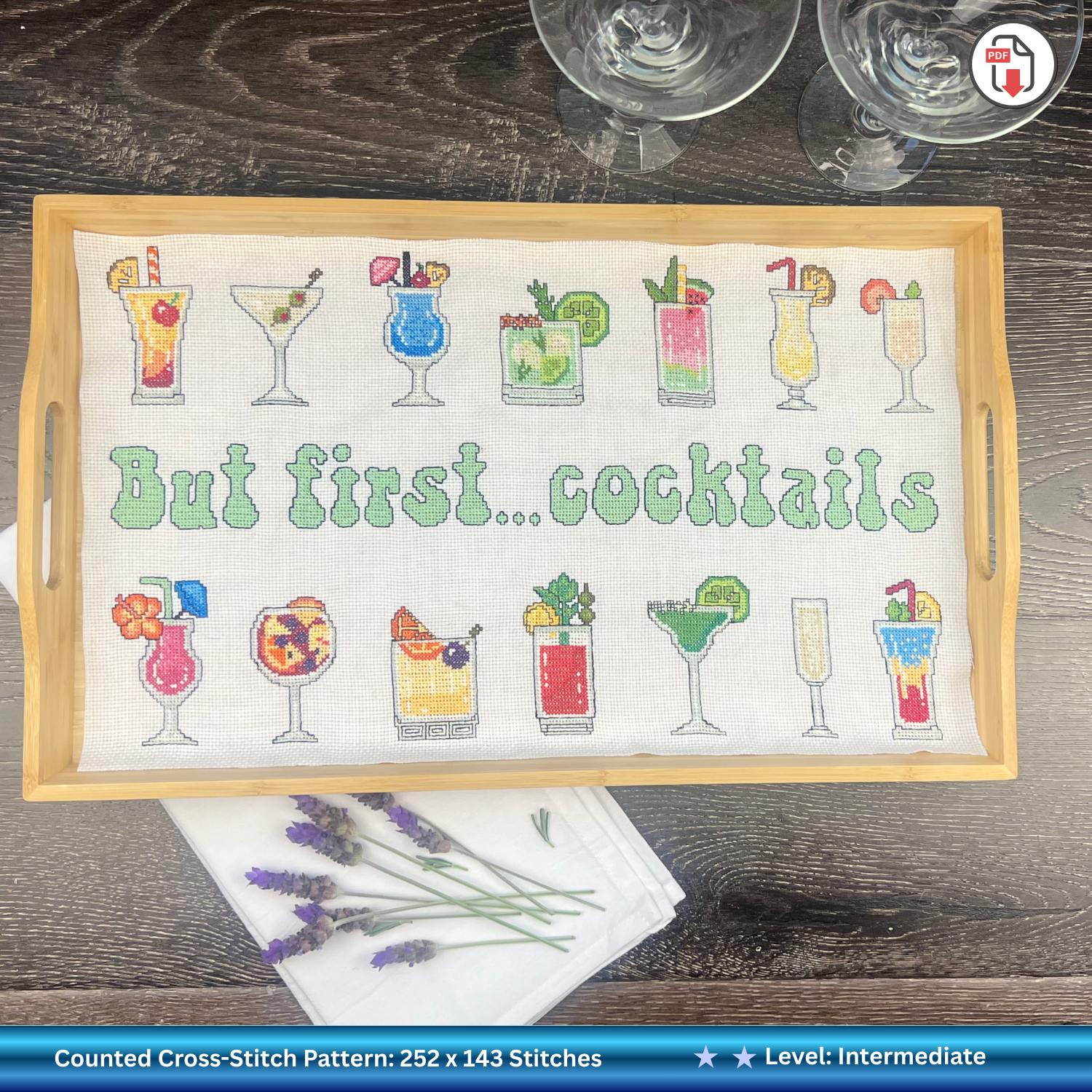 Cross-stitched tray with cocktail designs and 'But first... cocktails' text on a wooden tray.