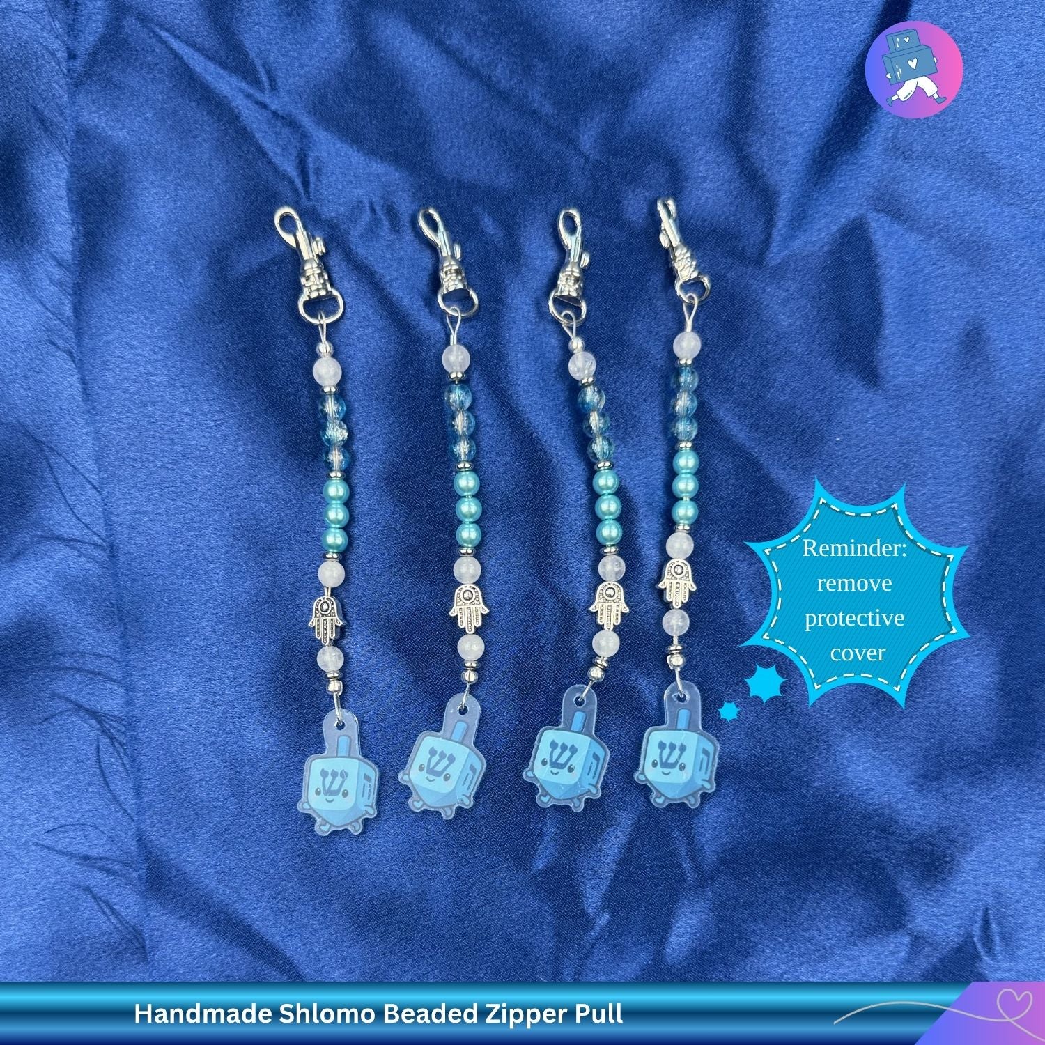 Set of handmade Shlomo beaded zipper pulls on a blue satin background