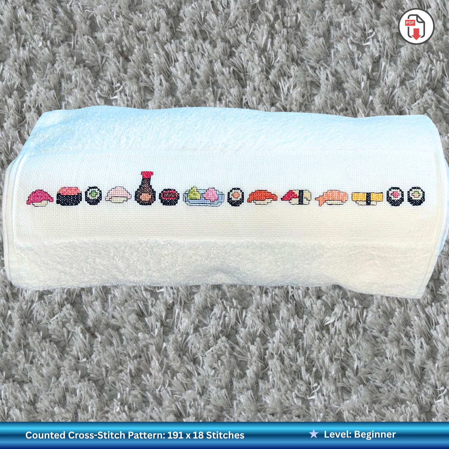 Cross-stitched sushi pattern on a white towel with a gray textured background