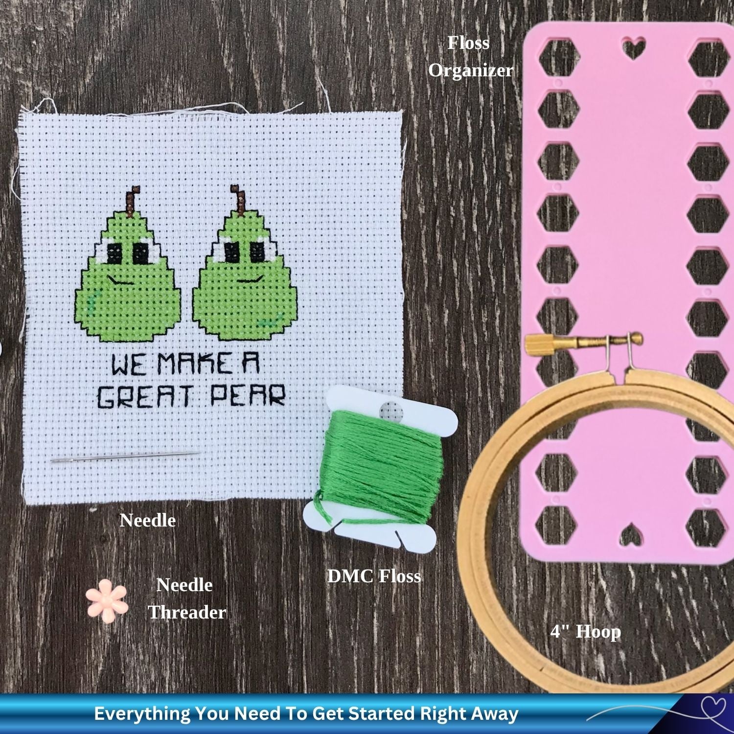 Embroidery kit with cross-stitched pears, floss, hoop, and organizer on a wooden surface.