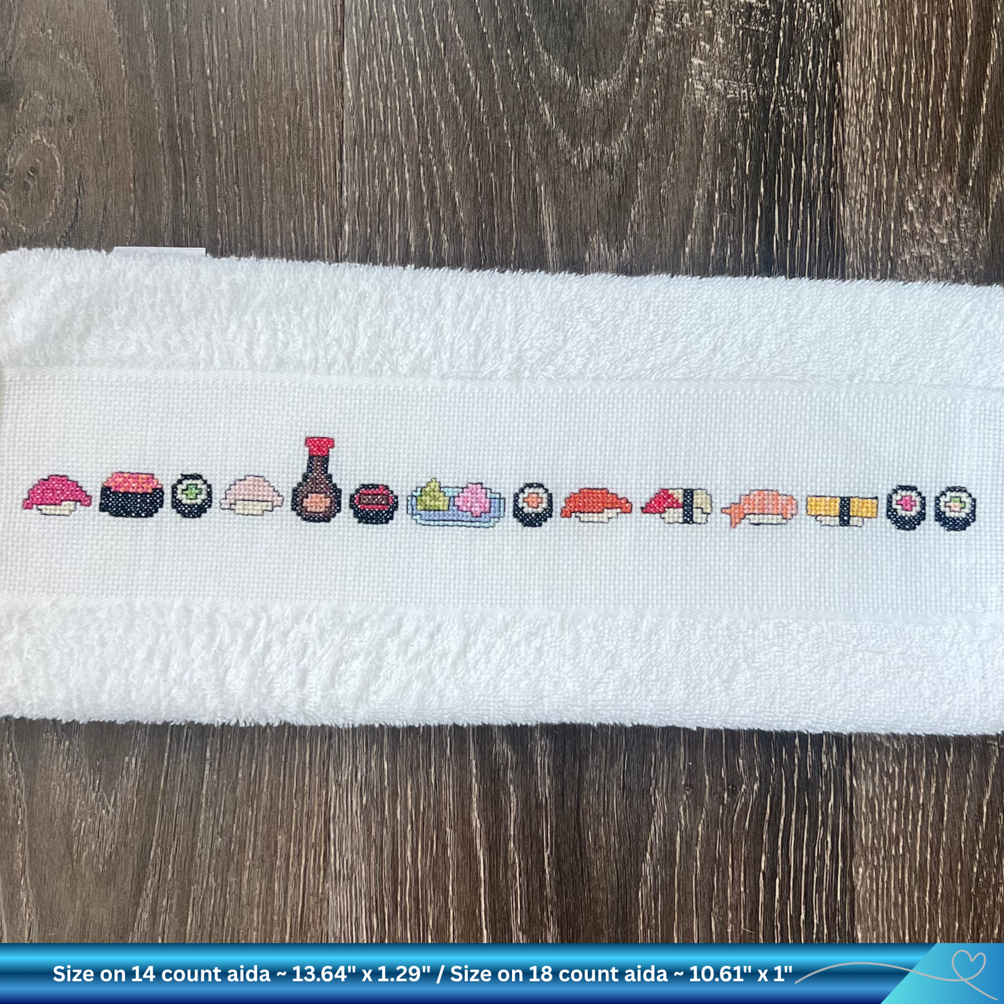 Cross-stitched sushi pattern on a white towel with text about size and fabric type.