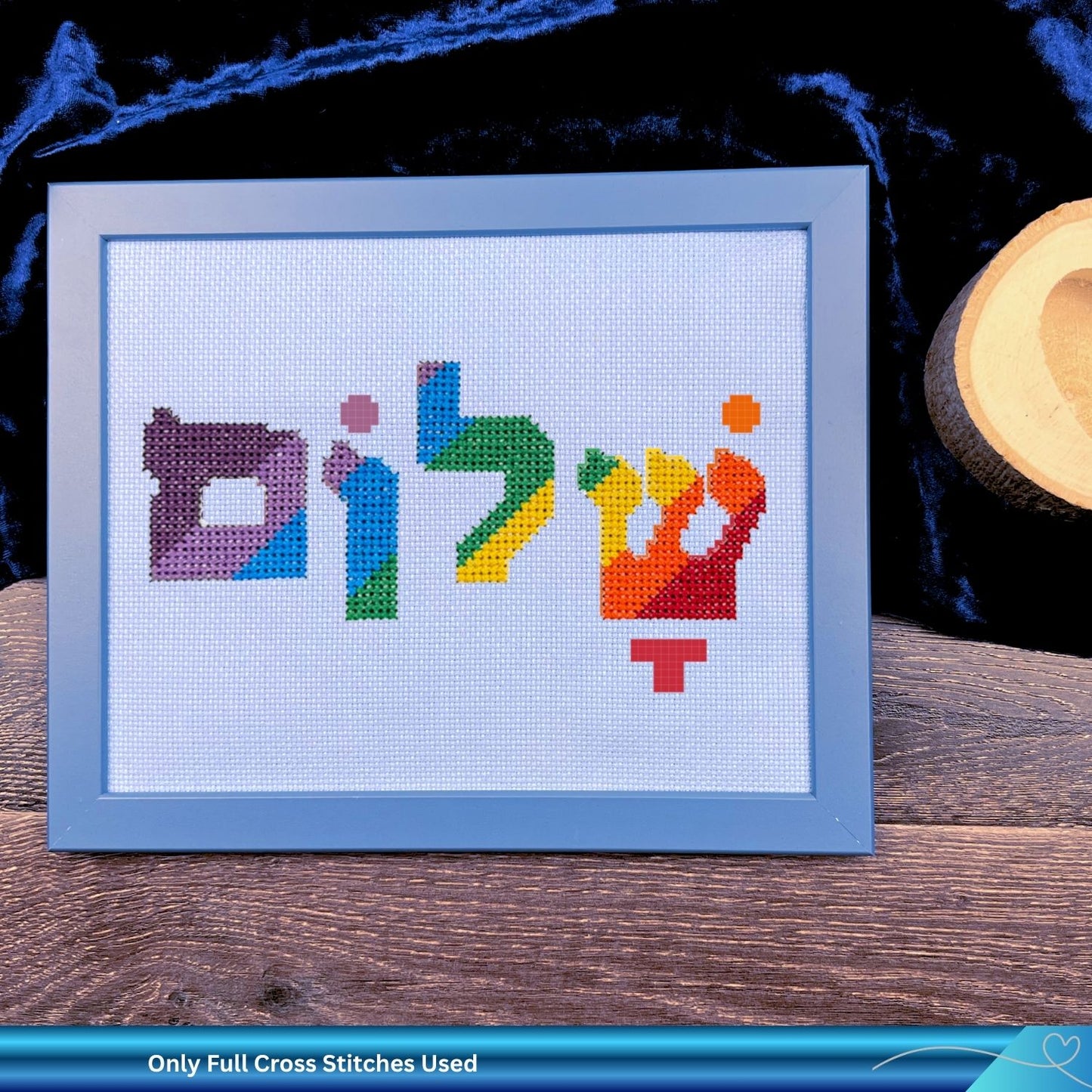 Embroidery hoop with colorful Hebrew letters on a white fabric background