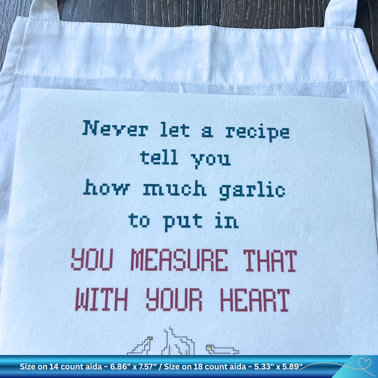 Light blue apron with embroidered text on a wooden surface