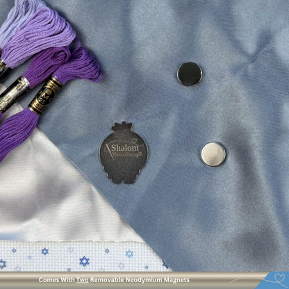 Embroidery floss with a blue fabric background and 'Shalom Needlecraft' branded magnetic needle minder.