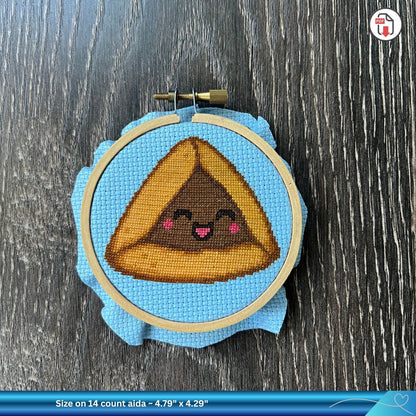 Cross-stitched design of a cute chocolate hamantaschen cross-stitch design on aida