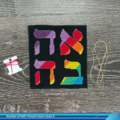 Cross-stitched project with colorful Hebrew letters on black fabric, surrounded by thread and a needle.