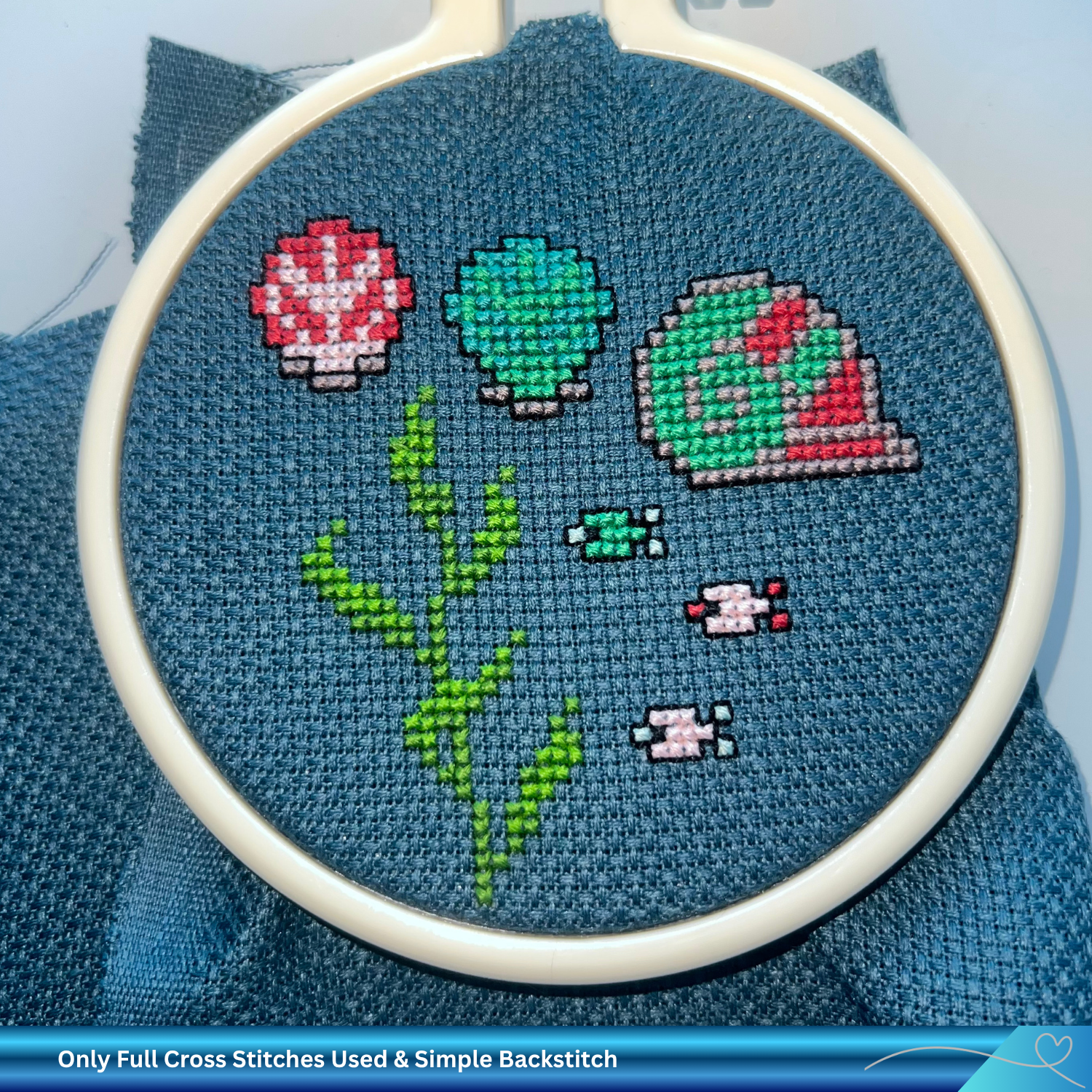 Embroidery hoop with sea life cross-stitched design on blue fabric