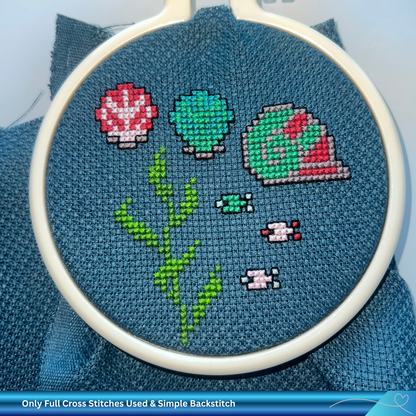 Embroidery hoop with sea life cross-stitched design on blue fabric