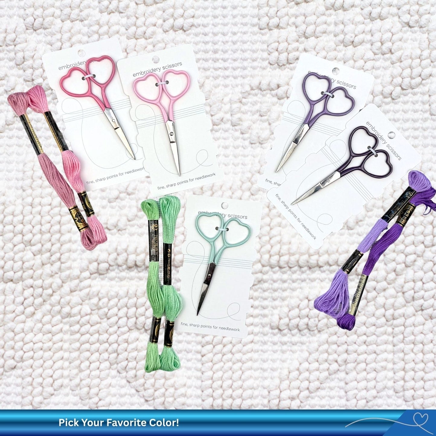 Heart-shaped scissors with embroidery floss on a textured white background