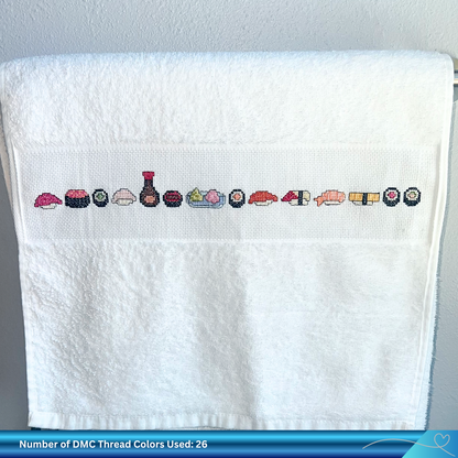 White towel with hand embroidered sushi designs on a gray background