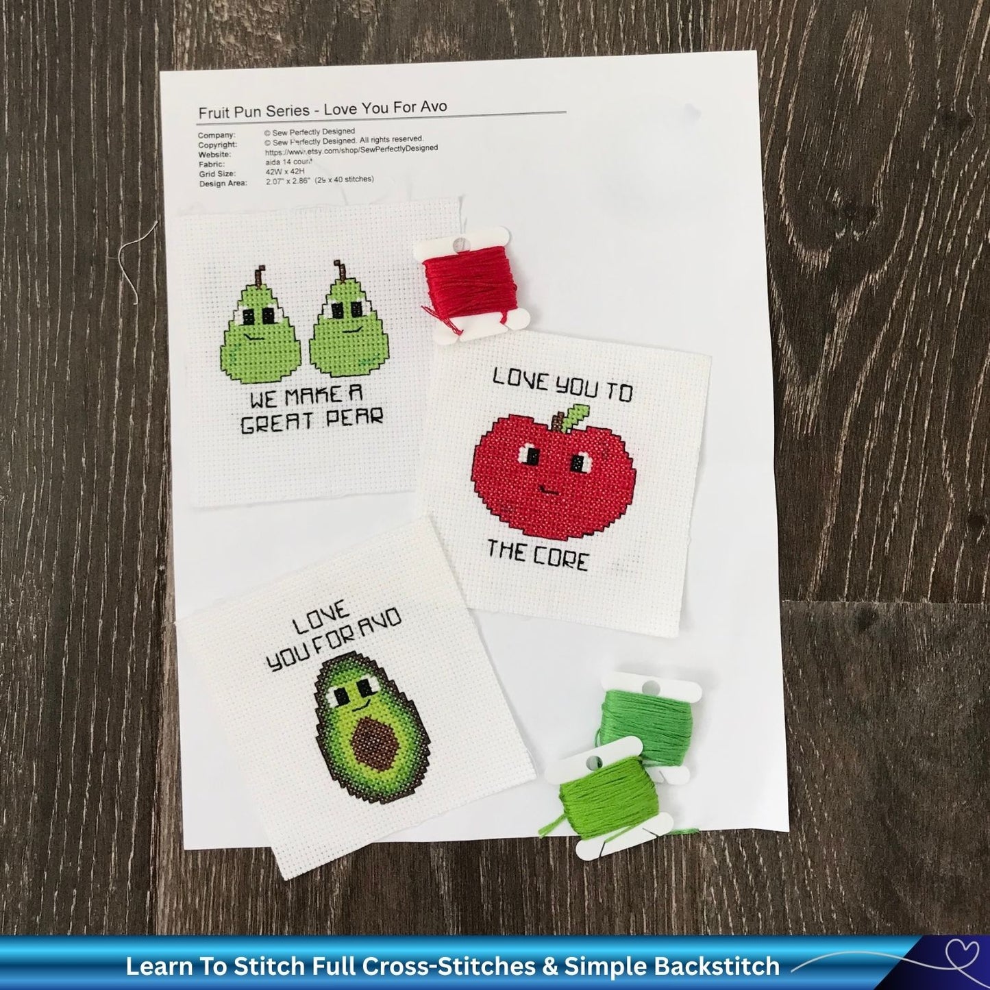 Cross-stitched patterns of fruits and vegetables on paper with a wooden surface background.