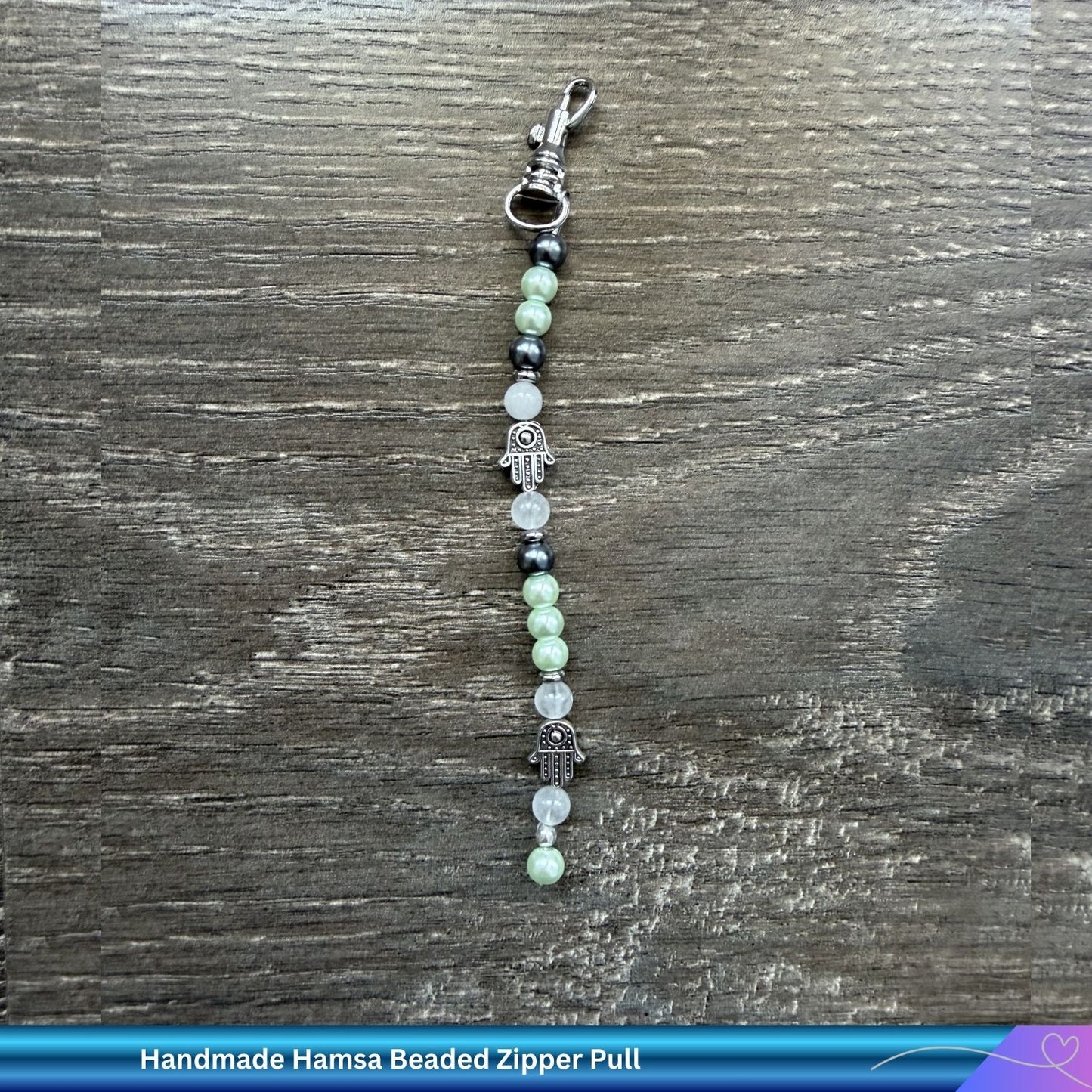 Pair of Judaica beaded zipper or bag charms on a wooden surface