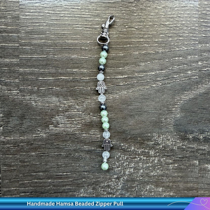 Pair of Judaica beaded zipper or bag charms on a wooden surface