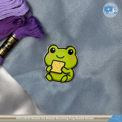 Green frog needle minder with a matzah on a gray fabric background
