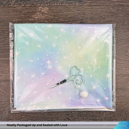 Packaged fabric with a needlepoint scissors and decorative scissor charm on  top of the fabric package