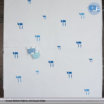 Cross-stitch fabric with blue Chai symbols on a wooden background