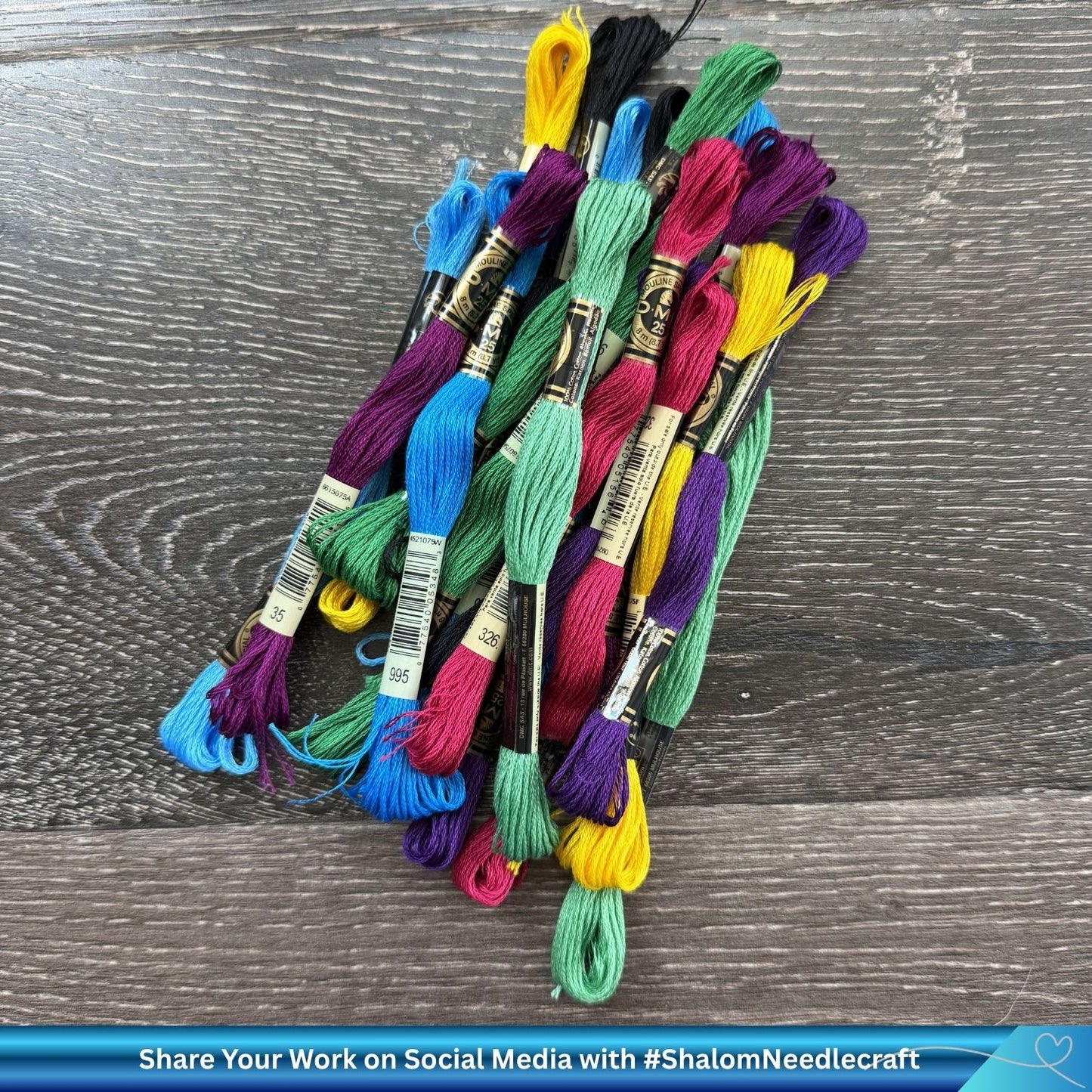 Bundle of colorful DMC cotton skeins against a wooden background