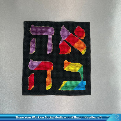 Hand embroidered word Love (Ahava) in rainbow colors on black Aida cotton