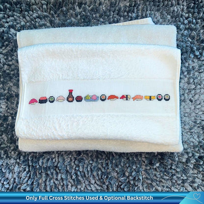 Folded towel with cross-stitched sushi design on a textured surface