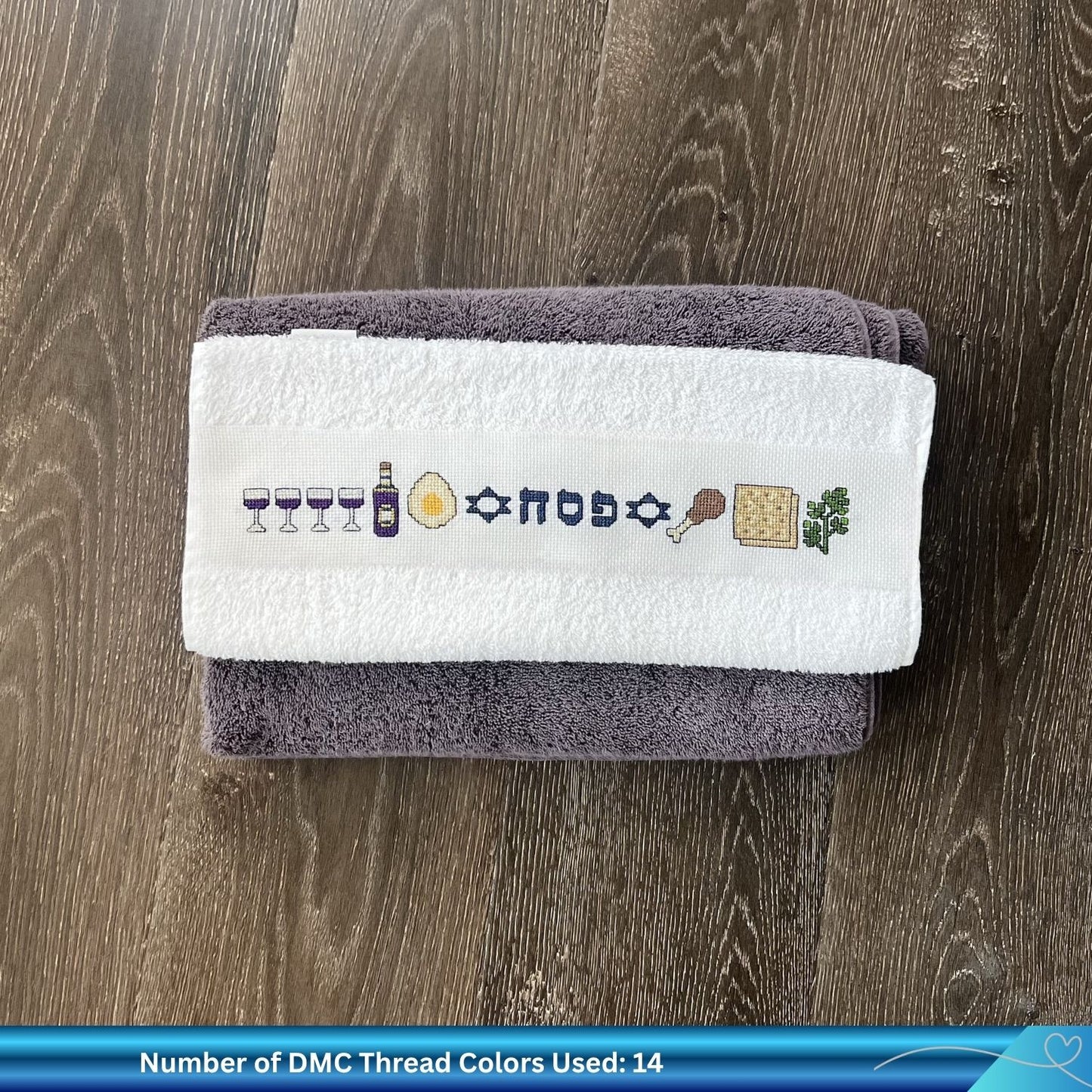 Hand cross-stitched Passover towel neatly folded on a wooden surface