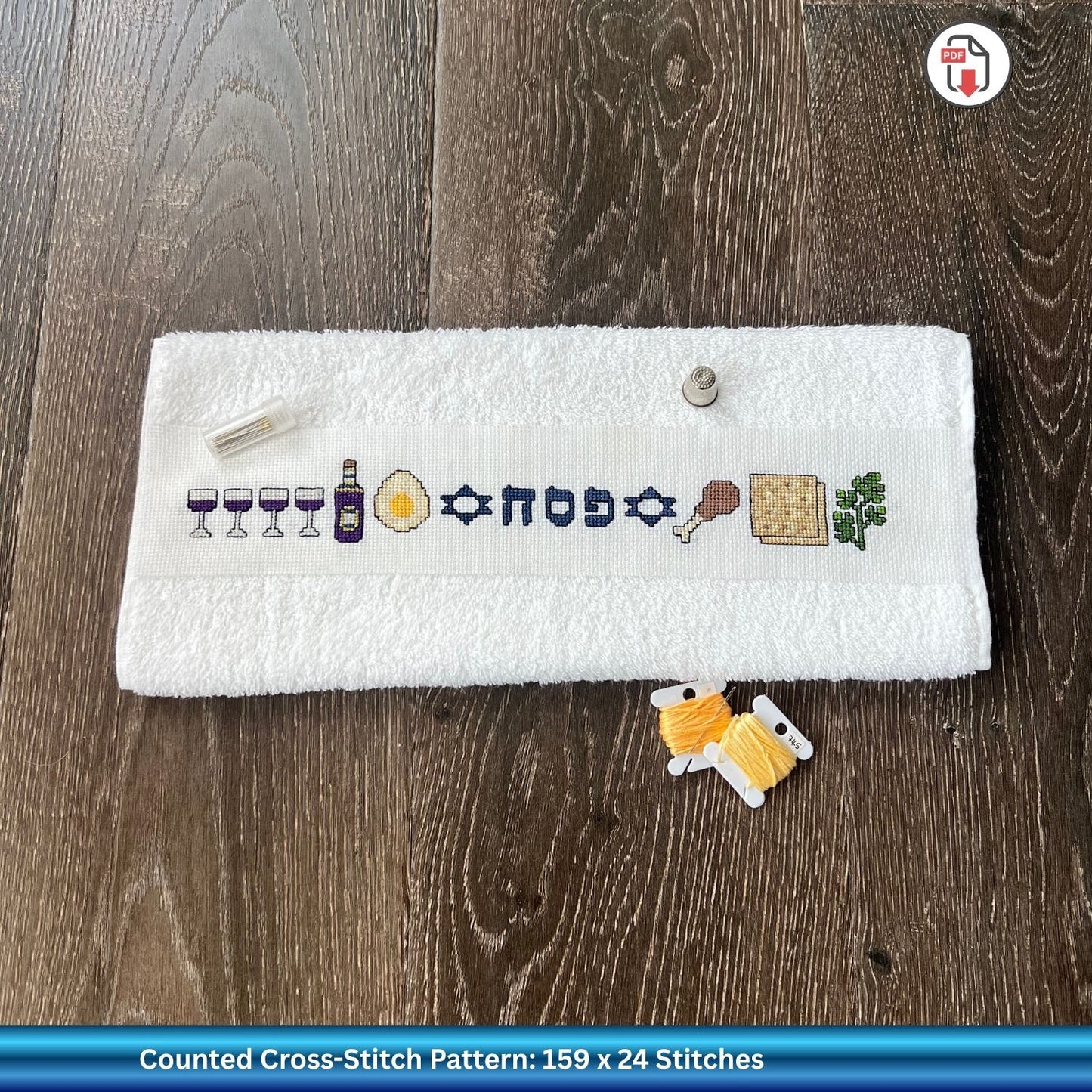 Counted cross-stitch Pesach design against a wooden surface.