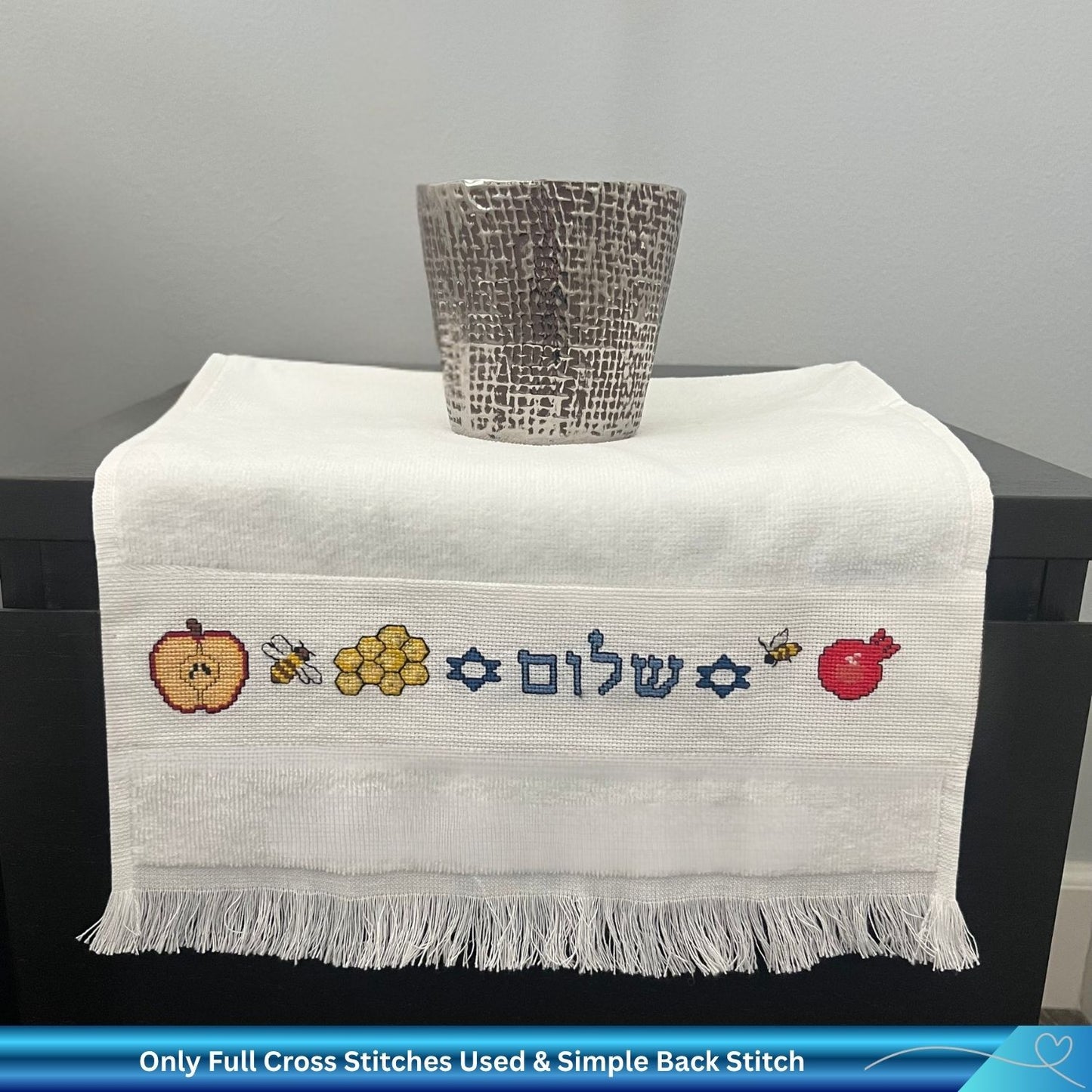 Cross stitch design for Rosh Hashanah with Apple, Bees, Honey and the Hebrew word Shalom stitched into a hand towel 