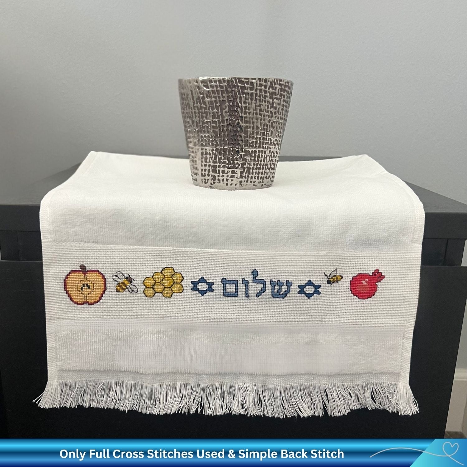 Cross stitch design for Rosh Hashanah with Apple, Bees, Honey and the Hebrew word Shalom stitched into a hand towel 