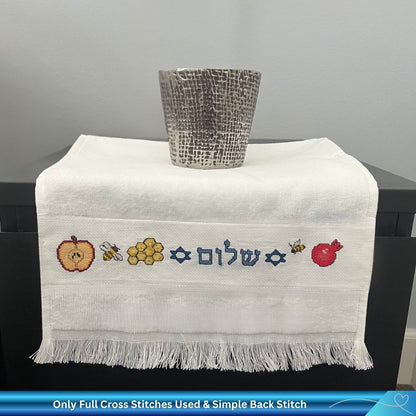 Cross stitch design for Rosh Hashanah with Apple, Bees, Honey and the Hebrew word Shalom stitched into a hand towel 