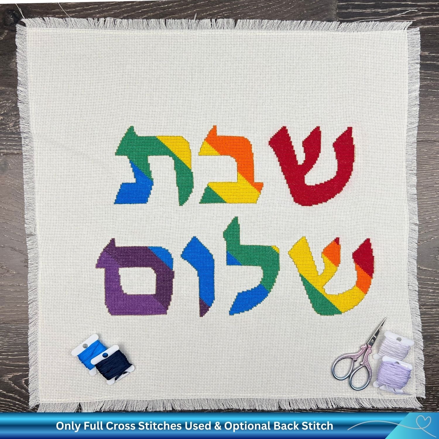 Hand embroidered cotton challah cover with cross-stitched Hebrew design on a wooden surface